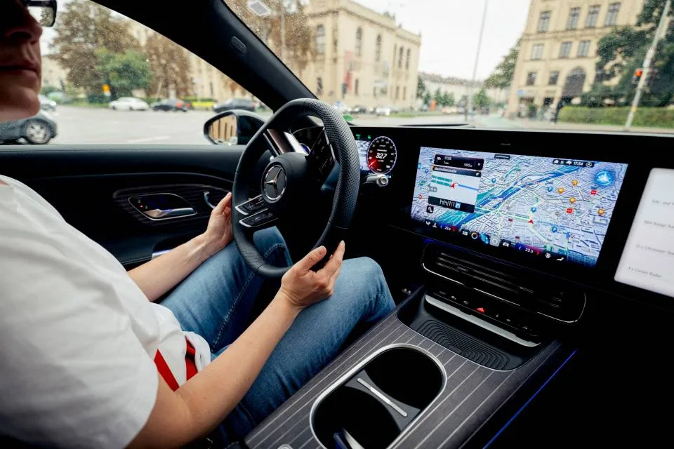 Driver holding wheel with city junction ahead